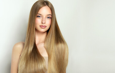 Beautiful model girl with shiny blonde and straight long  hair . Keratin  straightening . Treatment, care and spa procedures. Smooth hairstyle. 