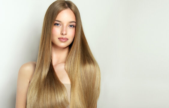 Fototapeta Beautiful model girl with shiny blonde and straight long  hair . Keratin  straightening . Treatment, care and spa procedures. Smooth hairstyle. 