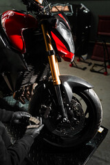 Front Brake Pad Replacement on Red Sport Motorcycle. Front brake pads are inspected and swapped out...