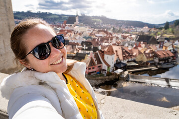 Mujer turista enseñando y compartiendo las vistas de český krumlov con una selfie