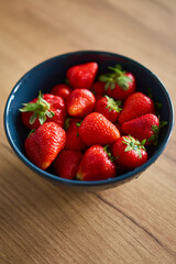 A beautifully vibrant bowl filled with fresh strawberries, showcasing their rich color, sweetness, and natural allure