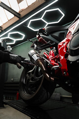 Exhaust Motorcycle System Maintenance. Mechanic tightening bolts on motorcycle chrome exhaust...