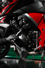 Obraz premium Mechanic working on motorcycle crankcase during full maintenance inspection. Motorcycle crankcase inspection with ratchet wrench ensures performance efficiency.