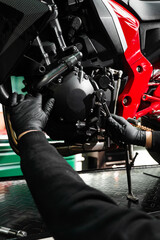 Mechanic working on motorcycle crankcase during full maintenance inspection. Motorcycle crankcase...