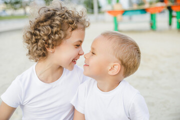 portrait of a boy and a girl, brother and sister. brother and sister looking at each other sweetly