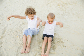 boy and girl blonde, brother and sister play in the sandbox and have fun