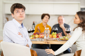 Dissatisfied guy turned away from the festive table, where his family and friends were having a...