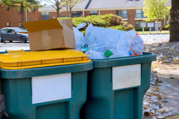 Town waste bins overflowing with garbage during works day in residential area