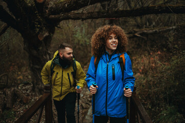 Hikers walking on wooden bridge in forest trail