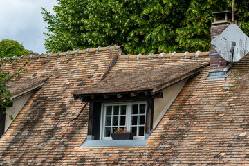 Tiled Roof with Dormer, Chimney, and Satellite Dish in Giverny, France.
