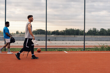 Basketball players leaving outdoor court after training