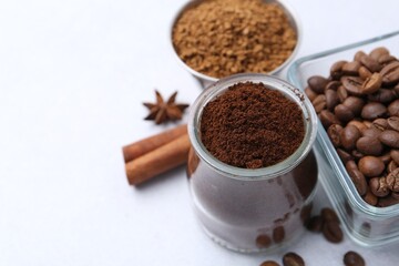 Different types of instant coffee, beans and spices on light table, closeup. Space for text