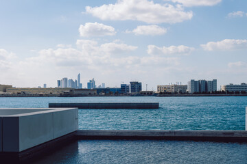 View of city with towers and skyscrapers from Saadiyat Island in Abu Dhabi, United Arab Emirates. View from water surface. High quality photo