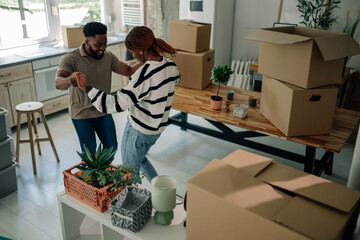 Happy couple dancing and celebrating moving into new home