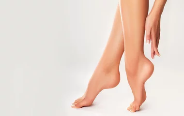  Perfect clean female feet . Beautiful and elegant groomed girl's hand touches her feet . Spa ,scrub and foot care . Woman legs © Sofia Zhuravetc