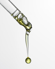 Pipette with serum, gel, oil or other cosmetic product with falling drop. Macro closeup