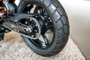 Close-up view of a motorcycle tire showcasing tread design and details on a gravel surface