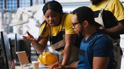 Black team of manufacturing plant employees fixing technical issues or errors, working together in the production line of solar panels at the industrial factory. Renewable energy. Camera A.