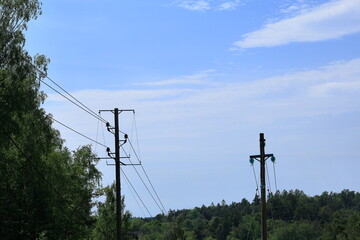 Wooden pole with electricity distribution. Green energy. Blue sky and summer day.