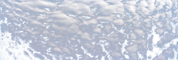 Panorama of puffy white summer clouds with a transparent sky
