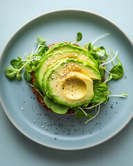 Open-faced veggie burger with avocado and sprouts on pastel blue plate