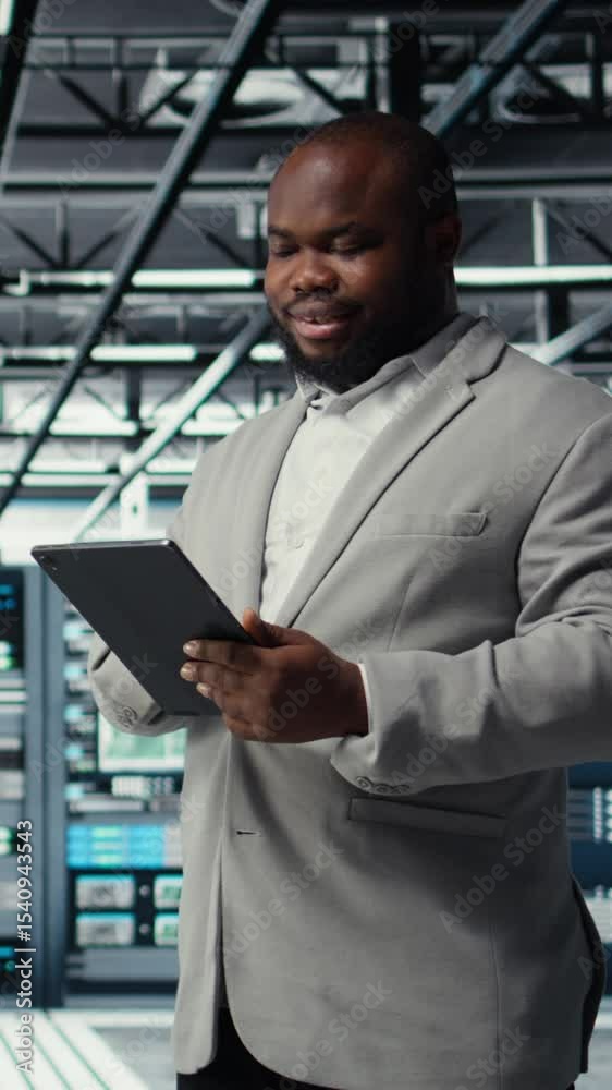 Poster vertical video cheerful data center programmer looking at code debugging tools running on tablet. se