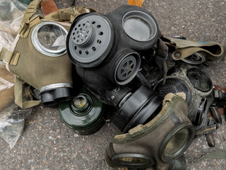 Assorted Military Gas Masks Piled on Ground