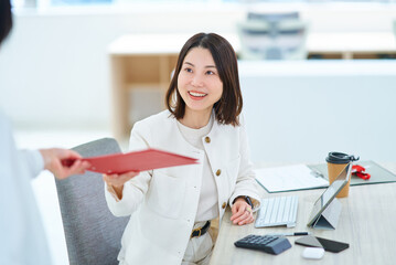 仕事中に同僚と会話する女性