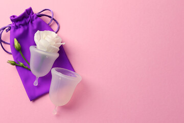 Eco-friendly menstrual cup and flowers on bright background. Space for text