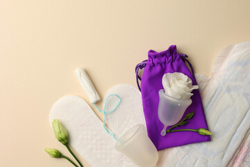 Eco-friendly menstrual cup and other feminine hygiene products on a bright background