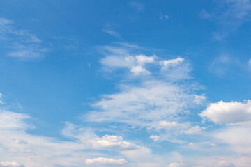 Expansive blue sky with fluffy white clouds, showcasing a serene atmosphere and bright daylight, perfect for backgrounds or nature-themed projects with copy space