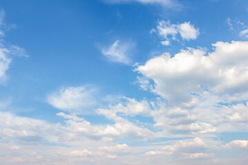 Fototapeta premium Expansive blue sky filled with fluffy white clouds, creating a serene atmosphere, ideal for backgrounds, design projects, and nature-themed visuals with copy space