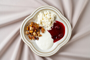 A carefully arranged platter features creamy yogurt, vibrant cherry compote, and crunchy granola on an elegant plate