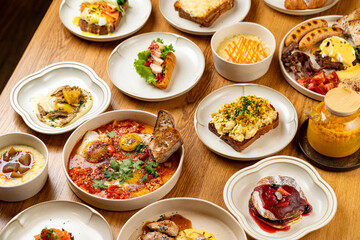 An inviting spread of various breakfast delights is artfully arranged on a rustic wooden table, showcasing vibrant colors and textures. Each dish offers a unique flavor profile, perfect for sharing