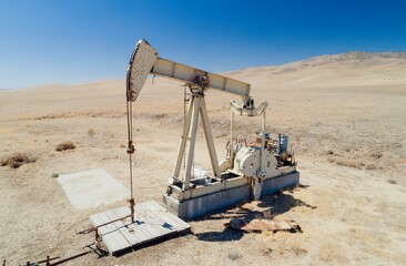 A Lufkin pumpjack extracts crude oil in a dry, arid landscape in Mckittrick, California, USA. The...