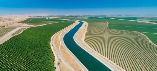 Aerial view of the California Aqueduct, a vital water source, flowing through farmland in California, USA. The canal irrigates crops in the arid landscape. Los Banos, California, USA © Zenstratus