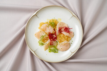 Savor a beautifully arranged seafood dish featuring tender scallops on a bed of fluffy couscous, garnished with vibrant herbs and vibrant strands of saffron, perfectly embodying culinary artistry