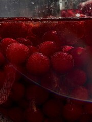 Home spins. Strawberry and sweet cherry compote. Red berries, water and sugar in a jar. Macro...
