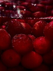 Home spins. Strawberry and sweet cherry compote. Red berries, water and sugar in a jar. Macro shooting berries in a jar before spinning. Sweet summer berries. The process of making compote.