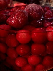 Home spins. Strawberry and sweet cherry compote. Red berries, water and sugar in a jar. Macro...