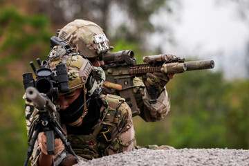 Fototapeta premium Special Forces Soldiers Armed and Ready During Tactical Training – Focused Military Men in Camouflage Uniform, Holding Assault Rifles, Outdoor Combat Operation in Desert Terrain