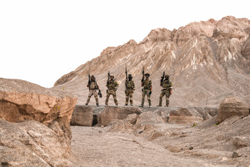 Special Forces Team Standing Together in Desert Mountain Terrain – Tactical Soldiers in Full Gear...