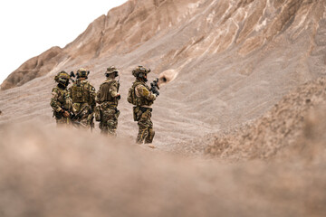 Special Forces Team Standing Together in Desert Mountain Terrain – Tactical Soldiers in Full Gear...