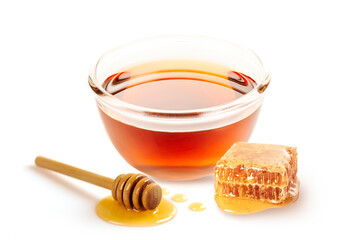 Glass of honey with honeycomb and dipper isolated on white background.