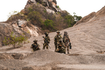 Special Forces Team Standing Together in Desert Mountain Terrain – Tactical Soldiers in Full Gear...
