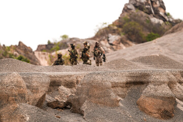 Special Forces Team Standing Together in Desert Mountain Terrain – Tactical Soldiers in Full Gear...