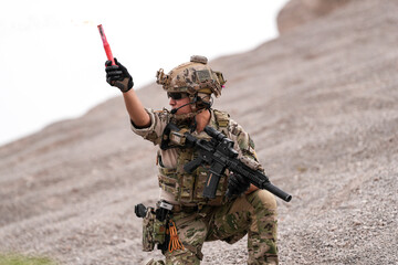 Special Forces Team During Military Operation on Rocky Slope – Soldier Holding Red Flare and...