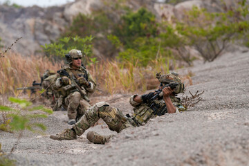 Special forces soldier uses a radio during a tactical operation while red flare smoke spreads...
