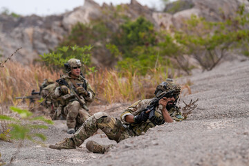 Special forces soldier uses a radio during a tactical operation while red flare smoke spreads...