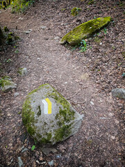 a stone painted with white and yellow stripes representing the right path at a crossroads, symbol of the right way